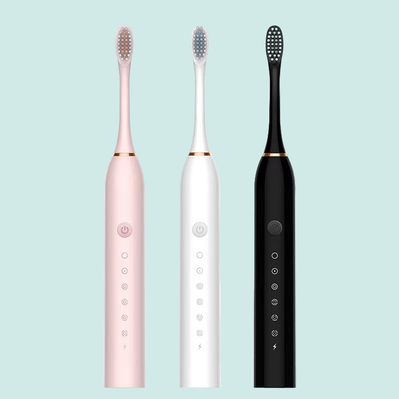Three electric toothbrushes in pink, white, and black on a white background